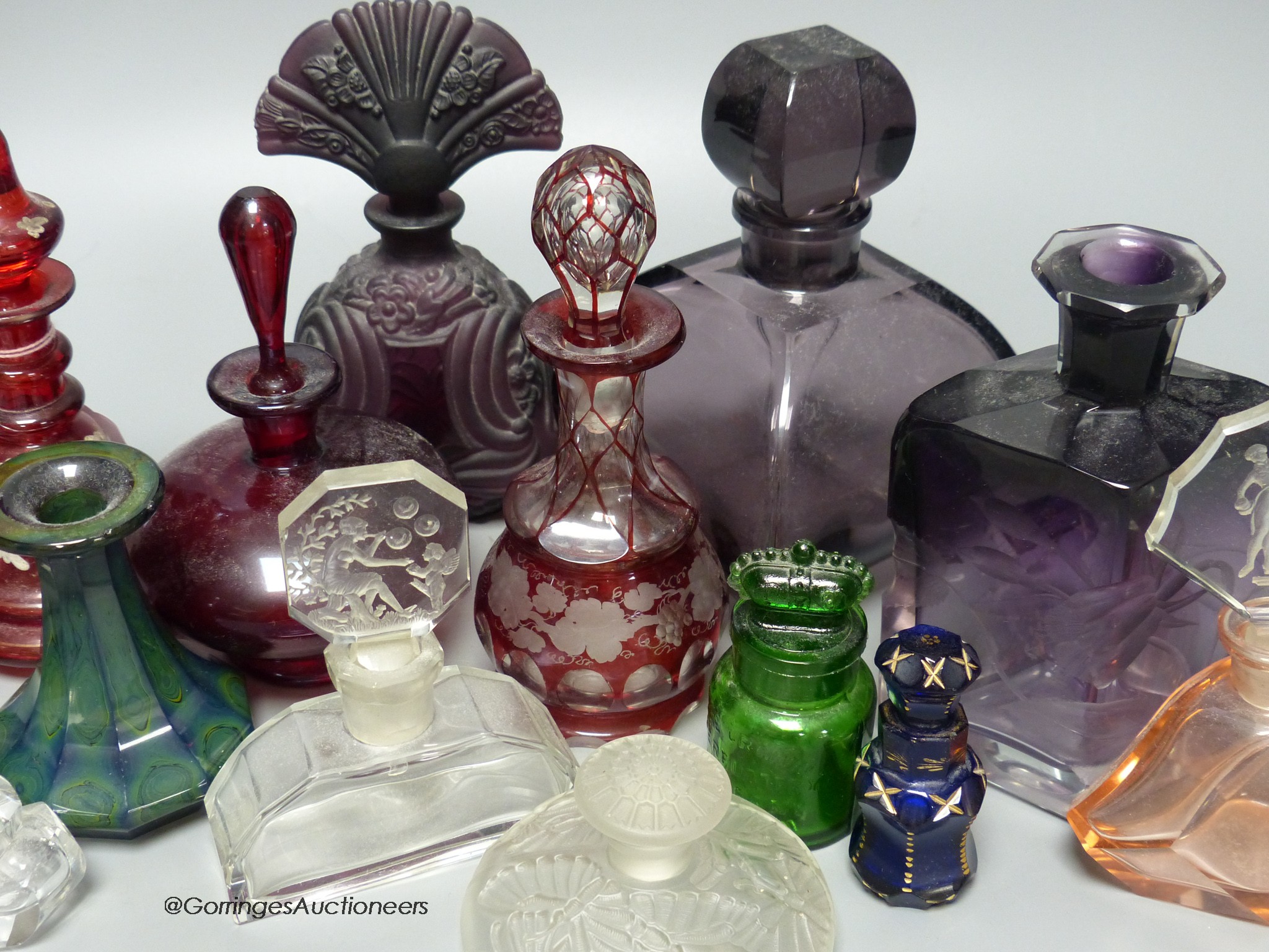 A collection of 1920's and earlier glass scent bottles to include ruby, amethyst, blue, clear and green